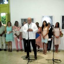 Alex Castro habla en la inauguración de su expo en Santiago. Detrás, las máximas autoridades de Santiago de Cuba, la escritora Teresa Melo y famniliares del Comandante en Jefe. Foto: Miguel Ángel Gaínza